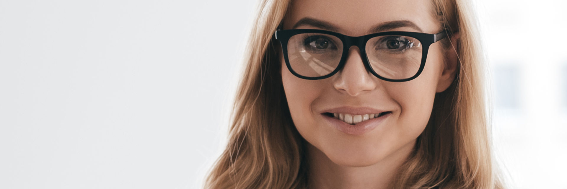 Woman wearing glasses showing beautiful teeth in her smile.