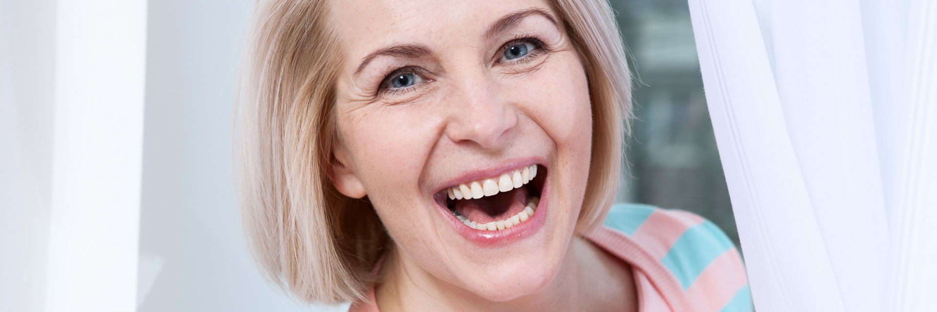 Happy mature woman showing her perfect teeth in a smile.