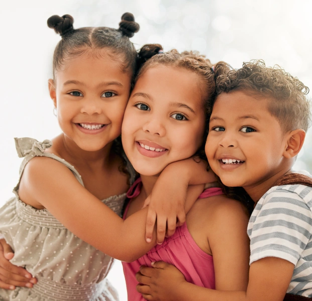 Smiling kids showing healthy teeth at a children’s dentistry clinic.